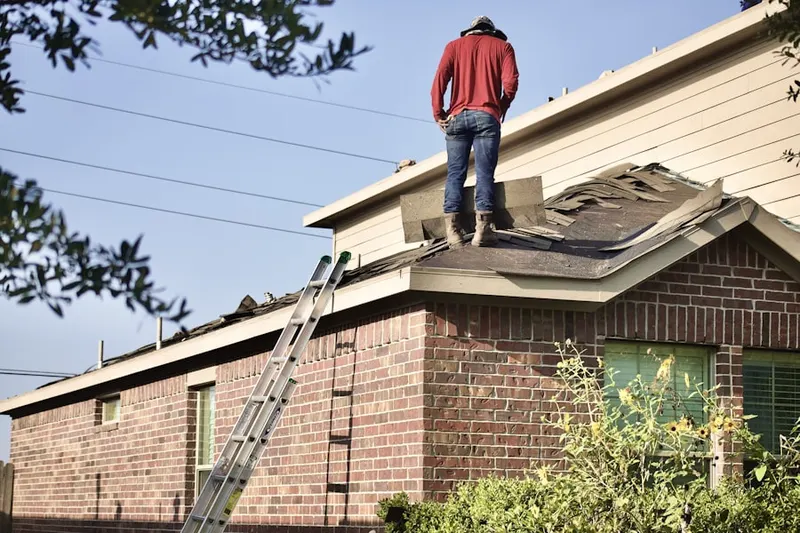 Professional roofer working on a residential roof in Riva Chase